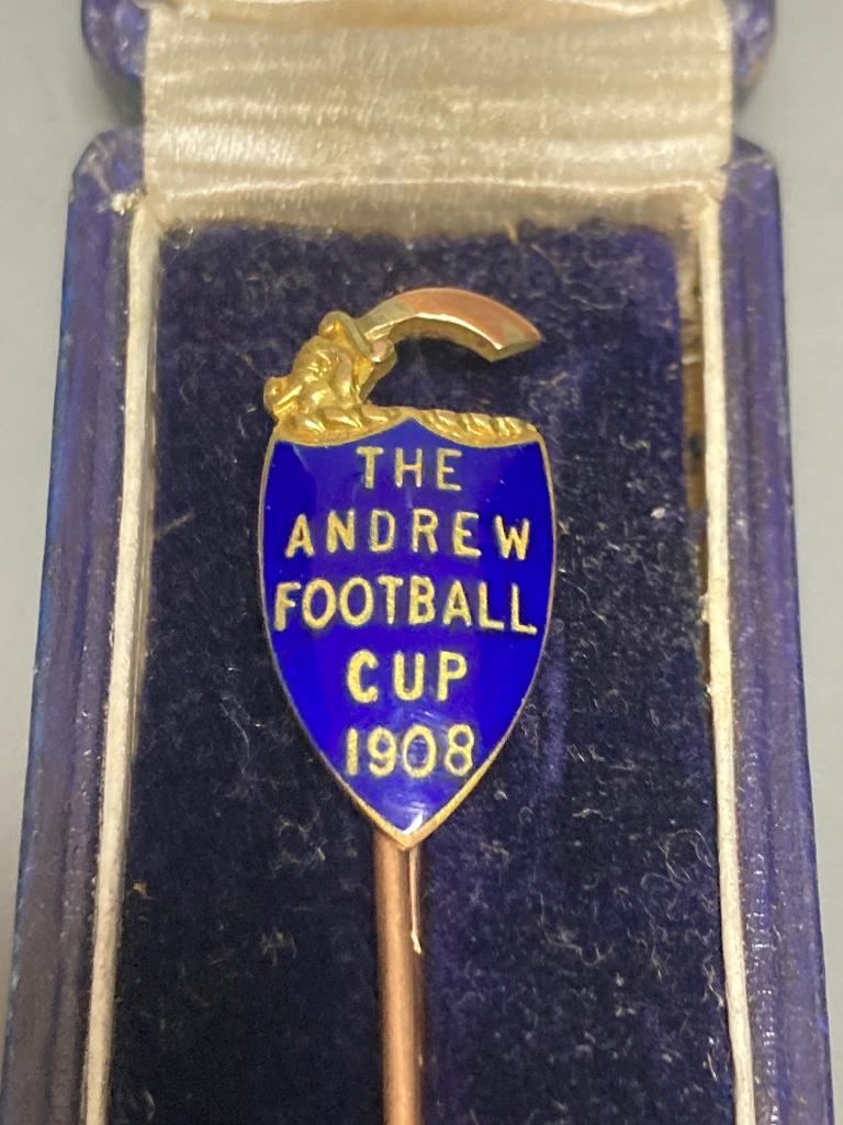 A 9ct gold and enamel 'The Andrew Football Cup, 1908' 68mm and one other 9ct gold stick pin, gross 6.1 grams.